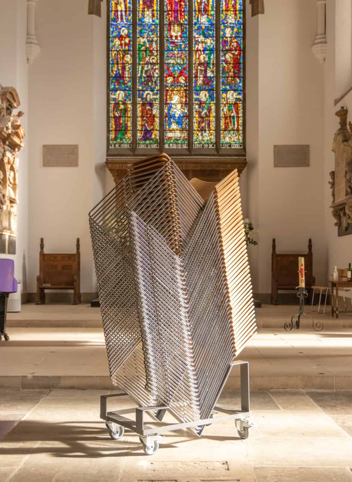 Stack of metal stacking chairs in a church on a trolley